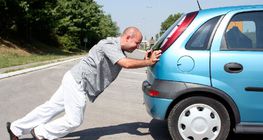 Чоловік штовхає авто